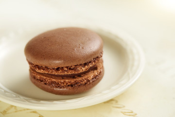 brown macaroon on a small white plate