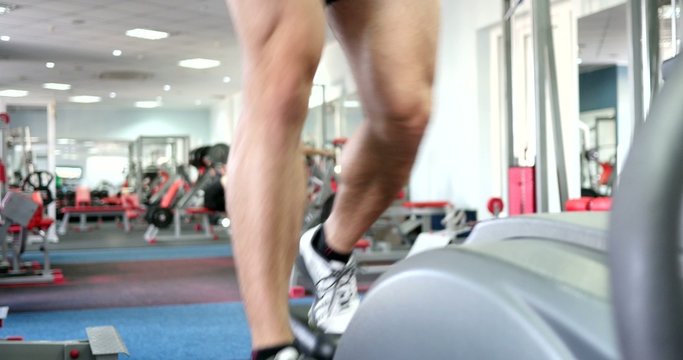 strong male sports leg on a simulator orbitrek