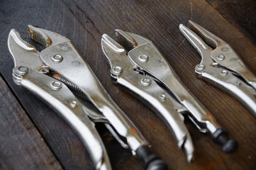 close up locking pliers on wooden background