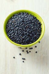 Fototapeta na wymiar black lentils on table in bowl