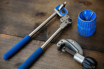 Tube bender or pipe bender tools on wooden background.