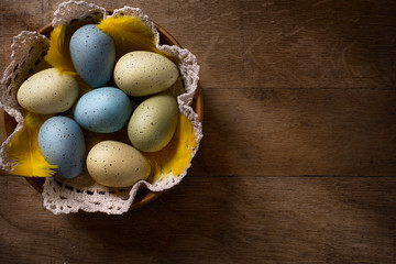 Obraz na płótnie Canvas Easter eggs in nest on rustic wooden table
