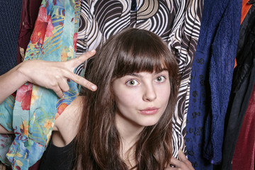 teenage girl with her wardrobe showing  a scissors with one hand