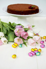 Obraz na płótnie Canvas Easter Chocolate Eggs, Tulips and Homemade Chocolate Cake