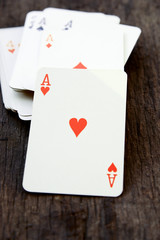 Deck of cards on wooden background (ace of heart)