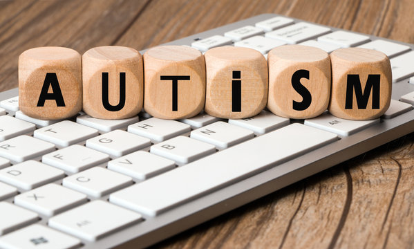 the word autism in wooden block dice