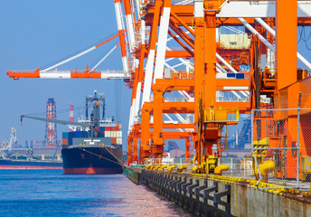 Cargo freight ship with stacked container at harbor terminal..