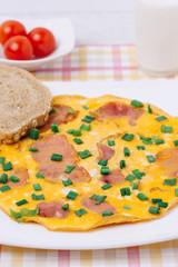 Omelet with ham and cherry tomato on a table
