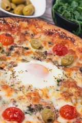 Delicious Italian pizza with egg in a center