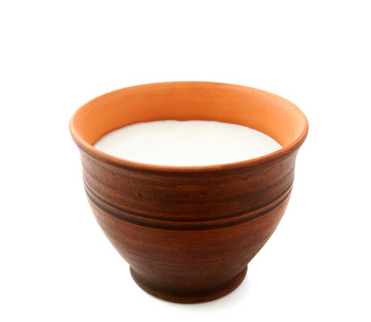 clay mug with milk on white background.