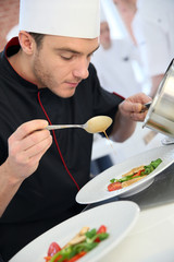 Chef in restaurant kitchen preparing dish