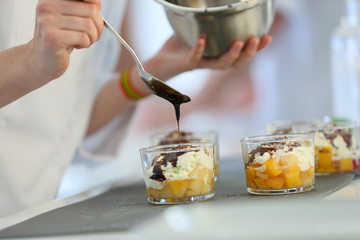 Closeup of chocolate being poured on dessert