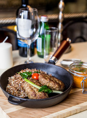 Restourant serving dish - cutlet with buckwheat on wooden board