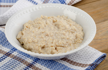 Bowl of oatmeal on wooden table. Healthy breakfast