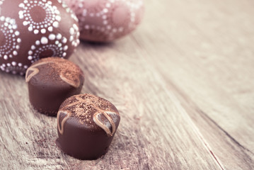 Closeup on chocolate truffles and eggs on wood