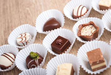 Wooden background with a row of chocolate pralines