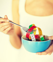 woman hands holding bowl with measuring tape