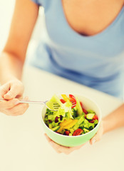 Obraz na płótnie Canvas woman eating salad with vegetables