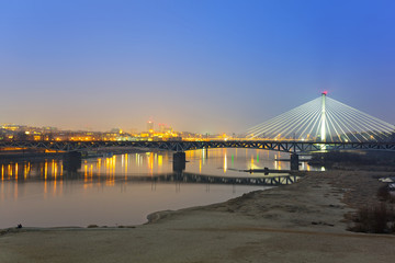 Obraz premium Panorama Warszawy nocą z odbiciem w Wiśle