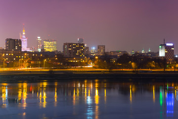 Fototapeta na wymiar Panorama of Warsaw at night with reflection in Vistula river