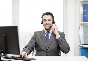 helpline operator with headphones and computer