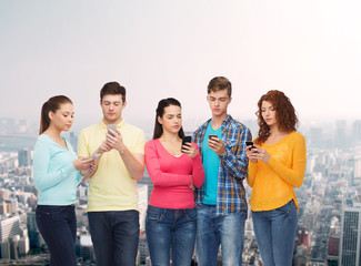 Obraz premium group of serious teenagers with smartphones