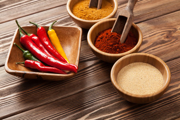 Bowls with spices on wood