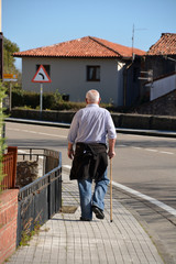 hombre mayor caminando por las calles de comillas