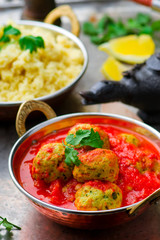 fish croquette in tomato sauce in a copper bowl