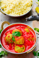 fish croquette in tomato sauce in a copper bowl