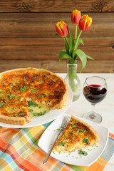 Cheese tart with red wine and red tulips on wooden background