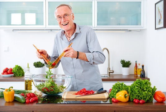 Mature man in the kitchen prepare salad VIII