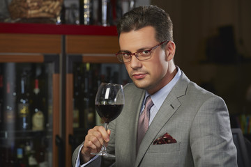 Wealthy successful gentleman toasting with wine in a restaurant