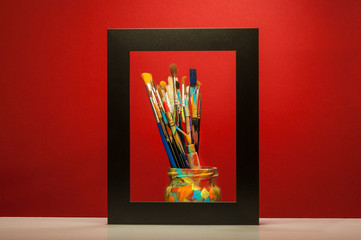 Arts painting brushes in frame with red background