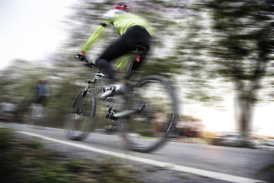 Low angle view of cyclist riding mountain bike with speed effect