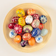 colorful easter eggs in wooden bowl