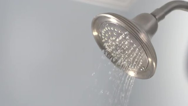 Slow motion water sprays from shower head.