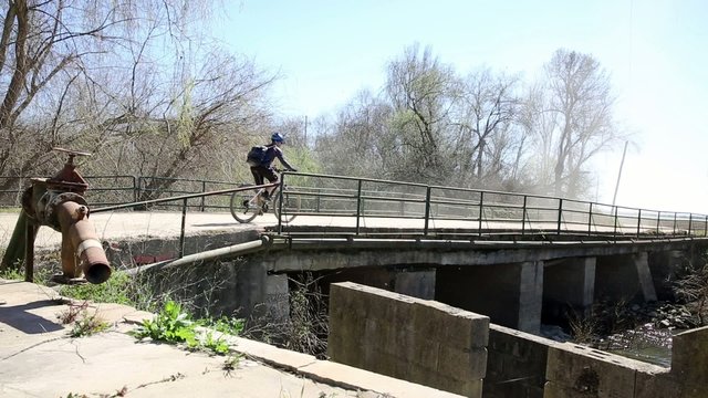 mountain bicycle riding on a country bridge