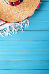 Mexican background with sombrero straw hat and traditional serape rug or blanket on old blue...
