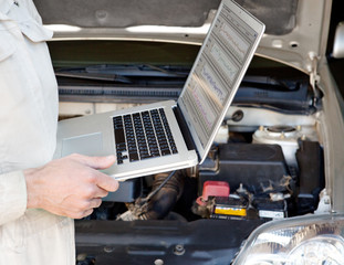 Car mechanic with laptop