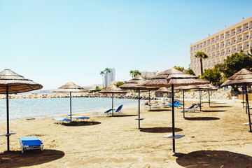 Fototapeta premium Sunshade Umbrellas with lounge chairs on the beach