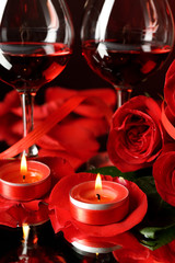 Composition with red wine in glasses, red rose and decorative