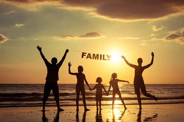 Happy family standing on the beach