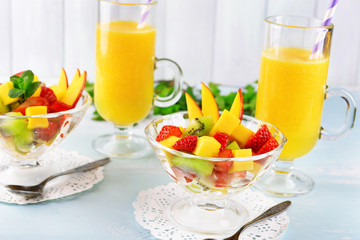 Fruit salad with mint and orange juice in glassware