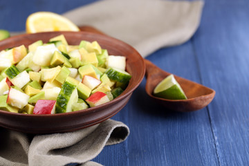 Salad with apple and avocado in bowl with napkin