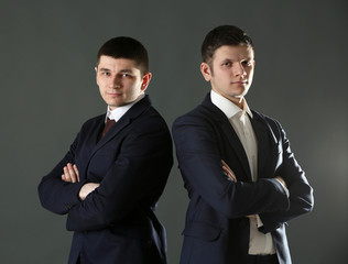 Two handsome businessmen on gray background