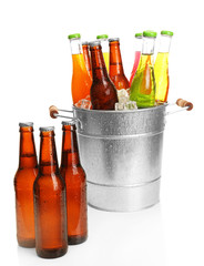 Glassware of different drinks in metal bucket with ice cubes