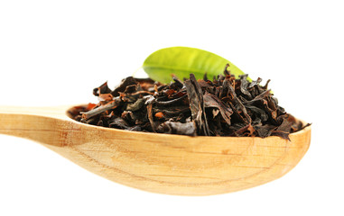 Cuillère en bois avec du thé noir avec des feuilles isolées sur blanc