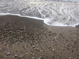 Галечный пляж на набегающей морской волной