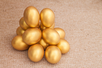Heap of golden easter egg on brown sack